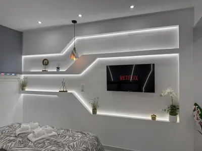 a living room with a tv on a wall at Smart Athens Stay, Studio Near Acropolis & Metro in Athens