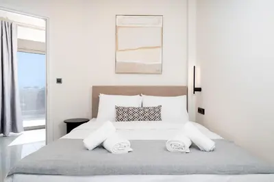 a white bedroom with a large bed with two towels at Acropolis View - Stylish City Penthouse with Large Terrace in Athens