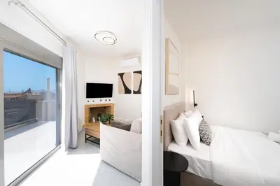 a bedroom with a bed and a living room with a fireplace at Acropolis View - Stylish City Penthouse with Large Terrace in Athens