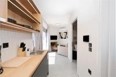 a kitchen with a sink and a living room at Acropolis View - Stylish City Penthouse with Large Terrace in Athens