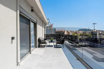 a balcony with chairs and a table on a building at Acropolis View - Stylish City Penthouse with Large Terrace in Athens