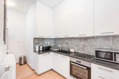 a kitchen with white cabinets and a microwave at Spacious apt with 2 beds and 2 baths in Pagrati in Athens