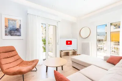 a white living room with a couch and a tv at Spacious apt with 2 beds and 2 baths in Pagrati in Athens