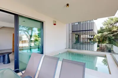 a house with a swimming pool and three chairs at Κ2 Varkiza Seaside Residences in Vari