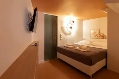 a small bedroom with a bed and a walk in shower at AthenianNest Sarri Boutique Studios Psyrri in Athens