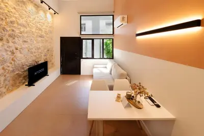 a living room with a white couch and a fireplace at AthenianNest Sarri Boutique Studios Psyrri in Athens