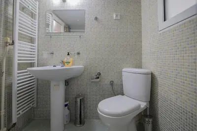 a bathroom with a white toilet and a sink at CitySoul Athens in Athens