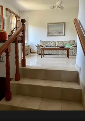 a staircase in a living room with a couch at Lagonisi 1 in Kalívia Thorikoú