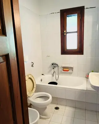 a bathroom with a toilet and a tub and a sink at Lagonisi 1 in Kalívia Thorikoú