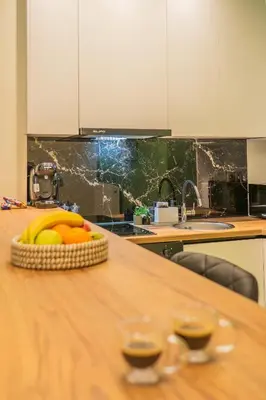 a table with a basket of fruit and two glasses of wine at Athens apartment near city centre in Athens