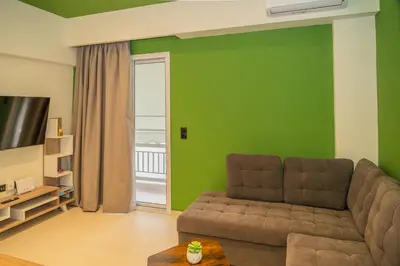 a living room with a couch and a green wall at Athens apartment near city centre in Athens