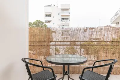 a glass table and two chairs on a balcony at South Metro Suite in Athens