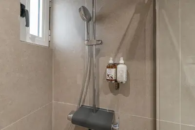a shower with two bottles of soap on the wall at South Metro Suite in Athens