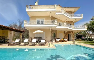 a villa with a swimming pool and a house at Gorgeous Home In Lagonisi With Wifi in Lagonissi