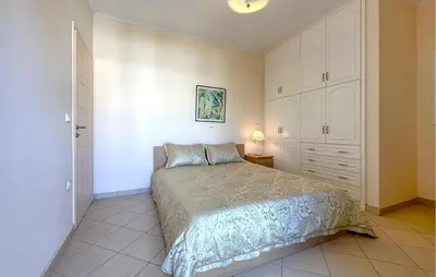 a bedroom with a bed and a dresser and a lamp at Gorgeous Home In Lagonisi With Wifi in Lagonissi