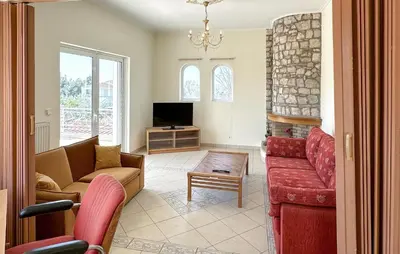 a living room with a couch and a tv at Gorgeous Home In Lagonisi With Wifi in Lagonissi
