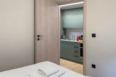 a room with a kitchen with a table and a door at Cozy 1BR with Balcony in Kipseli in Athens