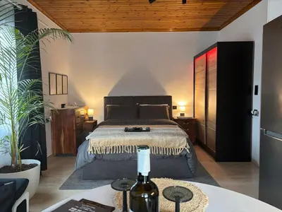 a bedroom with a bed and a table with a bottle of wine at 3R-in-3V in Vari
