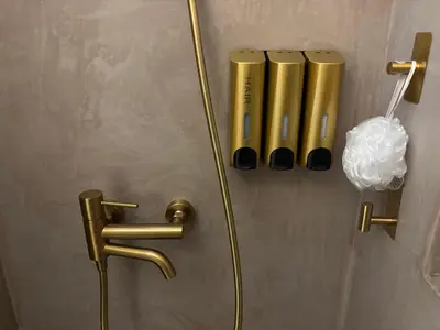a bathroom door with gold handles on a wall at 3R-in-3V in Vari