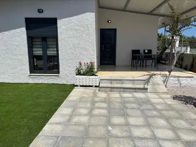 a house with a patio with a table and chairs at 3R-in-3V in Vari