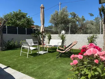 a yard with two chairs and a table and an umbrella at 3R-in-3V in Vari