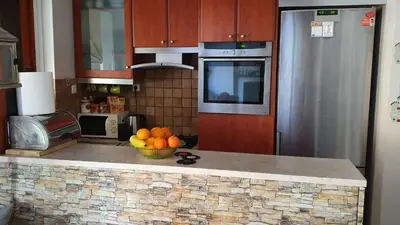 a kitchen with a bowl of fruit on a counter at Vresthenisden in Athens