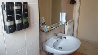 a bathroom with a white sink and a mirror at Vresthenisden in Athens