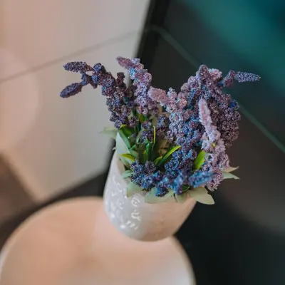 a white vase with purple flowers in it at Modern & Elegant Getaway near Pasalimani in Piraeus