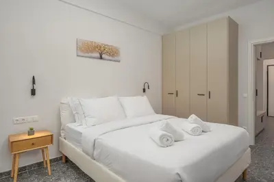 a bedroom with a white bed with towels on it at Modern & Elegant Getaway near Pasalimani in Piraeus