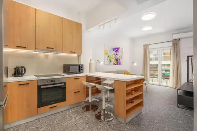 a kitchen with wooden cabinets and a counter top at Modern & Elegant Getaway near Pasalimani in Piraeus