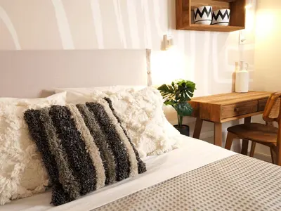 a bed with black and white pillows and a table at Graffiti House in Athens