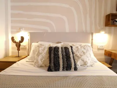 a bed with white sheets and pillows in a bedroom at Graffiti House in Athens