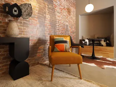 a living room with a chair and a brick wall at Graffiti House in Athens