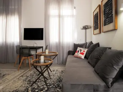 a living room with a gray couch and a table at Graffiti House in Athens