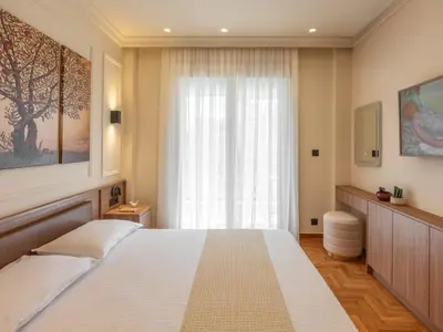 a bedroom with a large white bed and a window at Mixalakopoulou Luxury Apartment in Athens