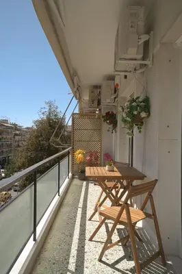 a balcony with a wooden table on a balcony at Mixalakopoulou Luxury Apartment in Athens