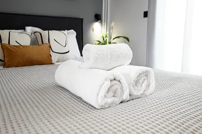 a pile of towels sitting on top of a bed at Sokratous house in Athens