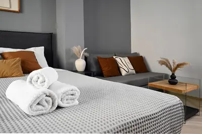 a bedroom with towels on a bed with a couch at Sokratous house in Athens