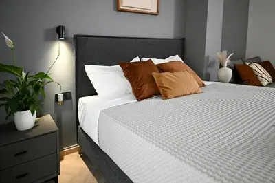 a bedroom with a white bed with pillows and a plant at Sokratous house in Athens