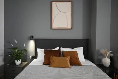 a bedroom with a bed with white sheets and orange pillows at Sokratous house in Athens