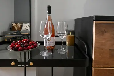 a bottle of wine and two wine glasses on a table at Sokratous house in Athens