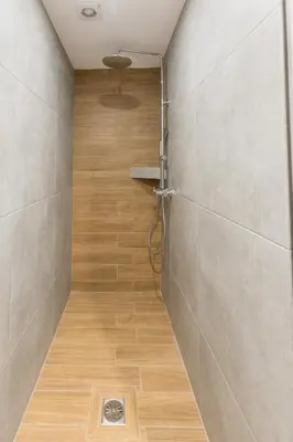 a bathroom with a shower with a wooden floor at Raise Egaleo Campus in Athens