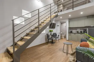a staircase in a living room with a table and chairs at Raise Egaleo Campus in Athens