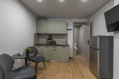 a kitchen with a refrigerator and a table and chairs at Raise Egaleo Campus in Athens
