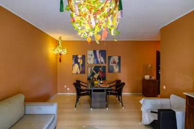a living room with a table and a chandelier at Dorina's Ath-seaside Apartment in Athens