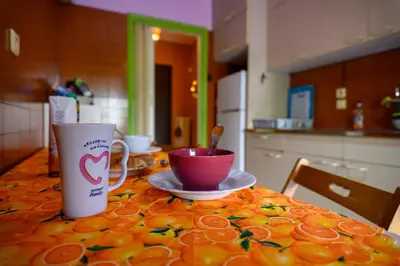 a table with a cup and a bowl of oranges on it at Dorina's Ath-seaside Apartment in Athens