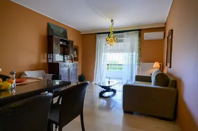 a kitchen and living room with a table and a couch at Dorina's Ath-seaside Apartment in Athens
