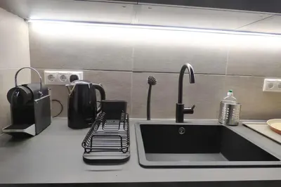 a kitchen counter with a sink and a coffee maker at Stylish city studio by MPS in Athens