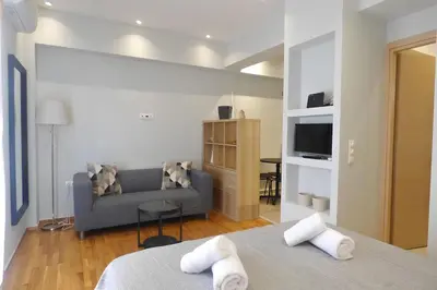 a living room with two beds and a couch at Stylish city studio by MPS in Athens
