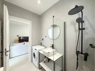 a bathroom with a sink and a washing machine at Athenian metro apartments in Athens